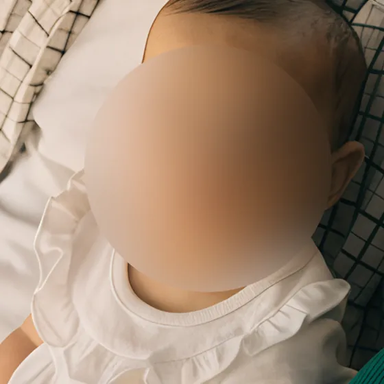 Un bébé au visage flouté.